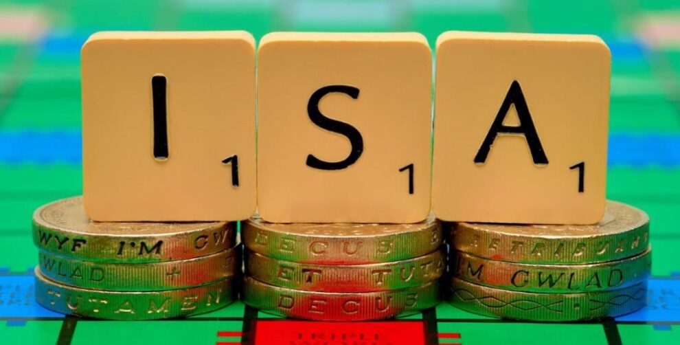 Scrabble letters spelling out the word "ISA" sitting on three-pound coins.